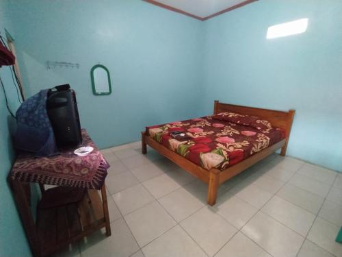 a small bedroom with a bed and a chair at Hotel O Tetirah Homestay in Salatiga