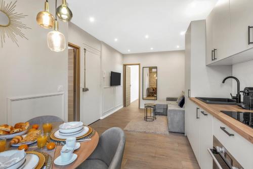 une cuisine et un salon avec une table et des chaises dans l'établissement Cannes Riviera By SCLS Locations, à Cannes