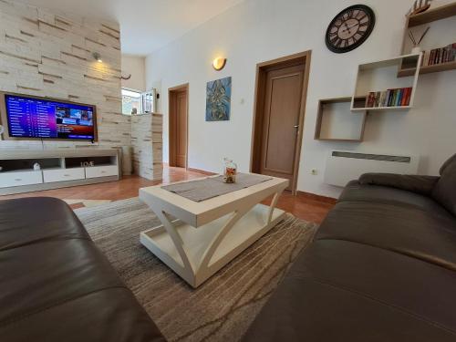 a living room with a couch and a table at Nina Apartment in Škaljari