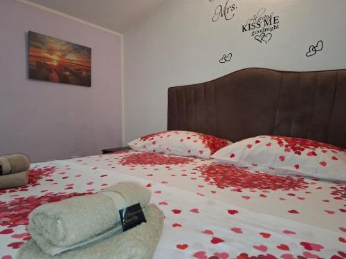 a bedroom with a bed with red flowers on it at Nina Apartment in Škaljari