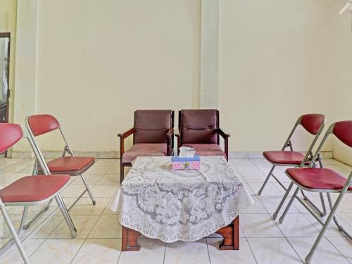 a group of chairs and a table in a room at Hotel O Excellent Kost in Jambi