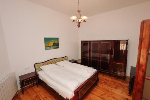 een slaapkamer met een bed en een kroonluchter bij Rezis sweet home in Tbilisi City