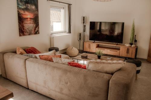 a living room with a couch and a flat screen tv at Résidence Alissa Charleroi Airport in Charleroi
