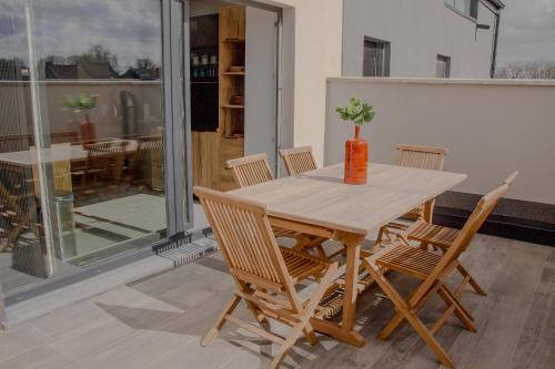 a wooden table with chairs and a vase on it at Résidence Alissa Charleroi Airport in Charleroi