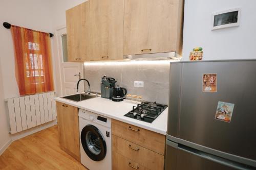 een keuken met een roestvrijstalen koelkast en een fornuis bij Rezis sweet home in Tbilisi City