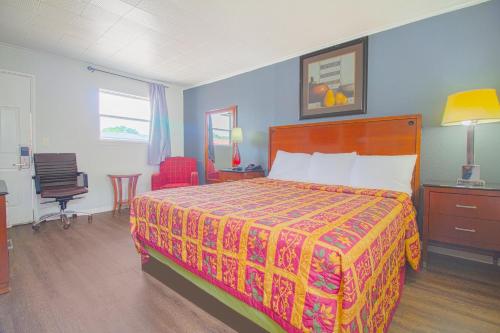 a bedroom with a bed and a desk and a chair at OYO Hotel McAlester OK S Main St in McAlester