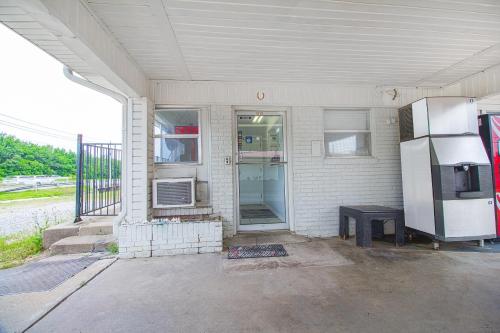 a white house with a refrigerator and a table at OYO Hotel McAlester OK S Main St in McAlester