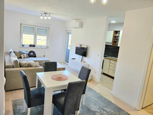 una sala de estar con una mesa y un sofá en Apartman Aura, en Bosanska Gradiška