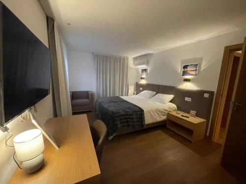 a small hotel room with a bed and a desk at Casa do Ferreiro T3 in Venda Nova