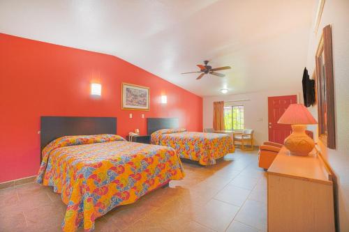 a bedroom with two beds and a ceiling fan at Vali Ho Motel By OYO Weslaco Mercedes in Weslaco