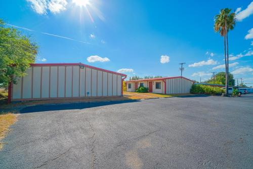 a parking lot with a building and a playground at Vali Ho Motel By OYO Weslaco Mercedes in Weslaco