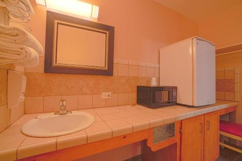 a bathroom with a sink and a refrigerator at Vali Ho Motel By OYO Weslaco Mercedes in Weslaco