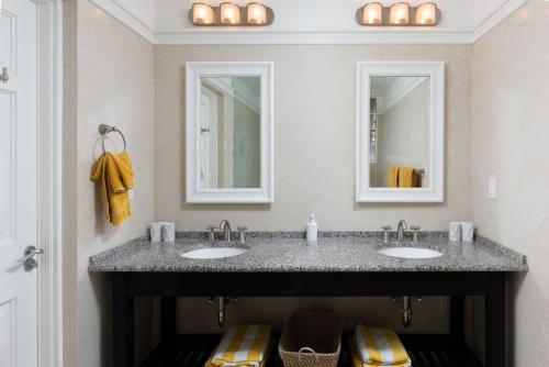 ein Badezimmer mit zwei Waschbecken und zwei Spiegeln in der Unterkunft Refreshing 2bed Townhome walking distance to beach in Saint James