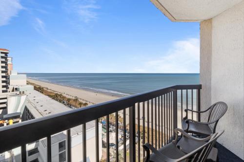 a balcony with a chair and a view of the beach at Compass Cove in Myrtle Beach