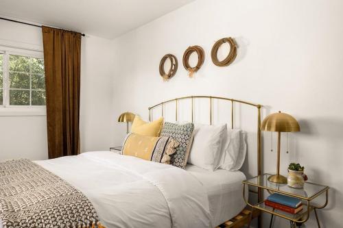 a bedroom with a bed and a table with a clock on the wall at Tranquil Gardens Soaking Pool Ember Stone in Yucca Valley