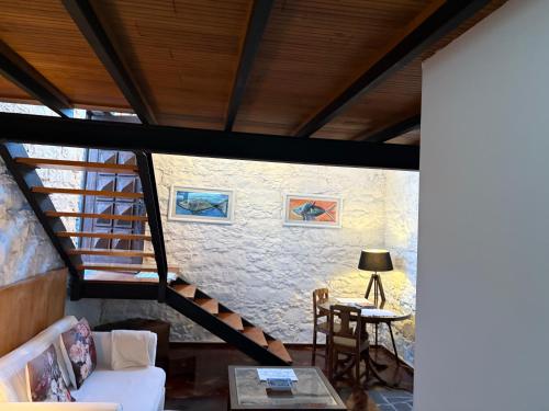 a living room with a staircase and a table at Casa do Poço Funchal in Funchal
