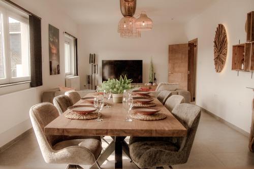a dining room with a long wooden table and chairs at Résidence Alissa Charleroi Airport in Charleroi