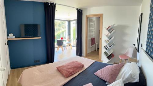 - une chambre avec des murs bleus et un lit avec des oreillers roses dans l'établissement Ty Nid d'Amour Ty Mamou, à Névez