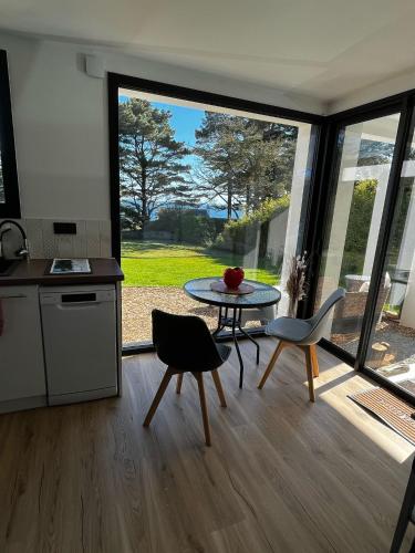 une cuisine et une salle à manger avec une table et des chaises dans l'établissement Ty Nid d'Amour Ty Mamou, à Névez