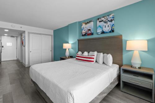 a bedroom with a white bed and blue walls at Compass Cove in Myrtle Beach