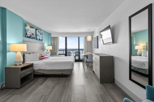 a bedroom with a bed and a desk with a mirror at Compass Cove in Myrtle Beach