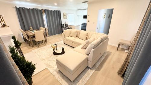 a living room with a white couch and a table at Newly renovated, warm home with 4 bedrooms, 14 miles from Disney in Whittier