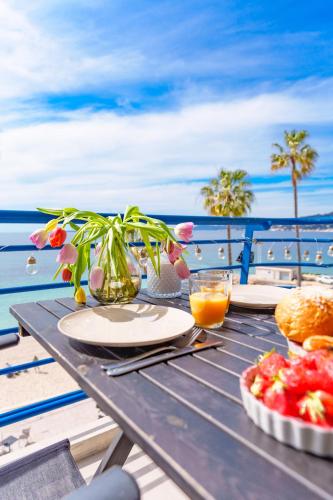 une table de pique-nique avec une assiette de nourriture sur la plage dans l'établissement Studio terrasse vue mer idyllique, à Antibes