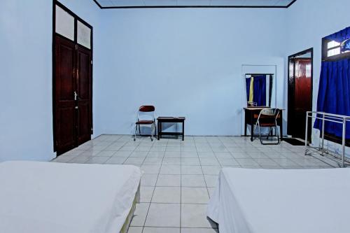 a room with chairs and a table and blue light at Hotel O Mareje Sariguna in Mataram