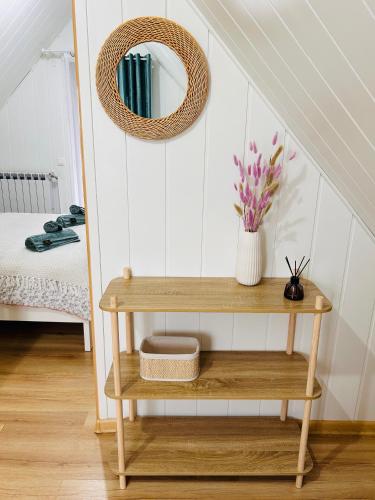 a small wooden shelf with a mirror and a table at Domek Natura in Rybno