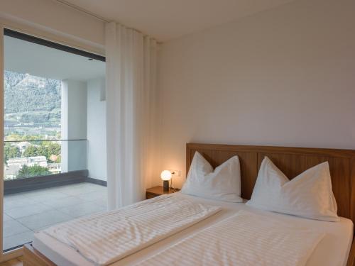 a bedroom with a bed with a large window at The Hills Merano in Merano