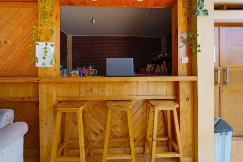a bar with stools and a laptop on a counter at Collection O 92634 Villa Ds in Sumedang