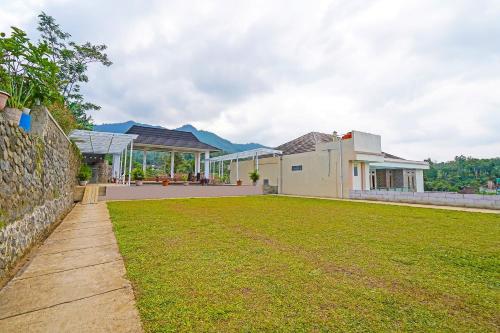 a house with a lawn in front of it at Collection O 92634 Villa Ds in Sumedang
