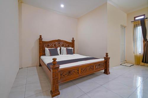 a bedroom with a wooden bed in a room at Collection O 92634 Villa Ds in Sumedang