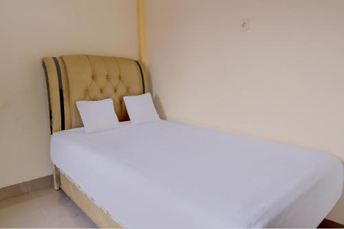 a white bed with two pillows on top of it at OYO Life 92637 Kost Arya Exclusive in Jambi
