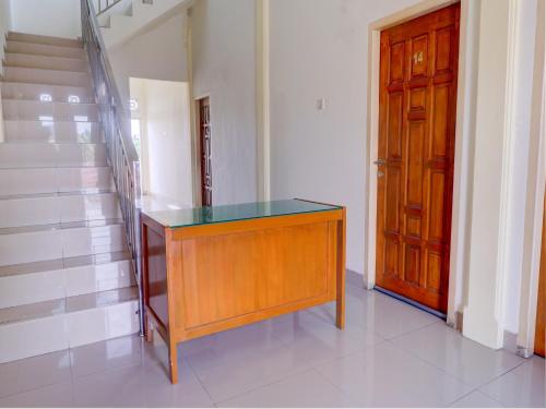 a wooden cabinet with a glass top next to a door at OYO Life 92637 Kost Arya Exclusive in Jambi