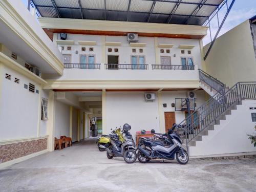two motorcycles parked in front of a building at OYO Life 92637 Kost Arya Exclusive in Jambi