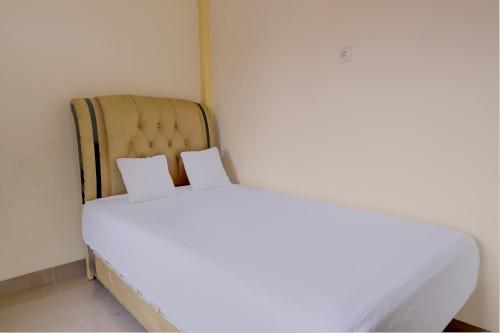a white bed with two pillows on top of it at OYO Life 92637 Kost Arya Exclusive in Jambi