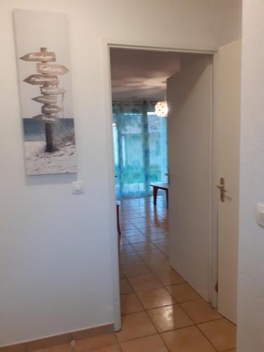 un corridoio con una porta e un dipinto sul muro di Appt T3 Résidence Le Cordouan 3 étoiles avec piscines et sauna a Soulac-sur-Mer