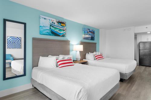 two beds in a hotel room with blue walls at Compass Cove in Myrtle Beach