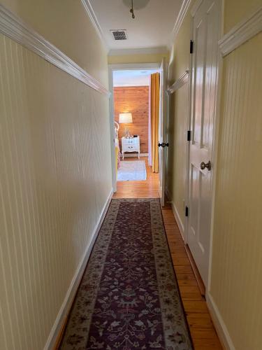an empty hallway with a rug on the floor and a door at Yellow Daisy Bed and Breakfast in Dahlonega
