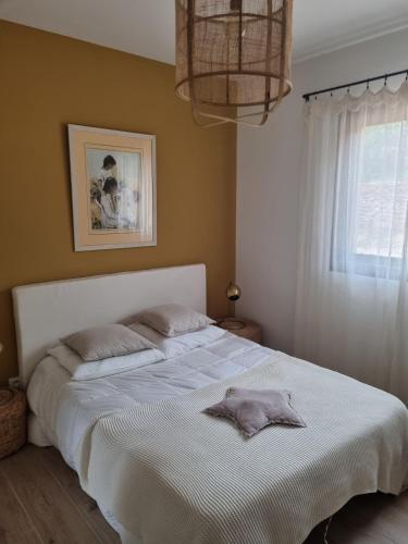 une chambre avec un grand lit blanc et une fenêtre dans l'établissement Villa Les Aludes, aux Lecques