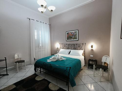 a bedroom with a bed with a green blanket at La casa di Elena a San Gregorio di Catania in San Gregorio di Catania