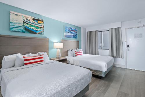 two beds in a hotel room with blue walls at Compass Cove in Myrtle Beach