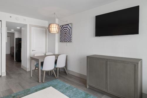 a dining room with a table and a tv on a wall at Compass Cove in Myrtle Beach