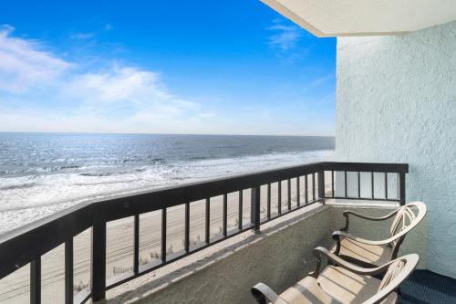 two chairs sitting on a balcony overlooking the ocean at Compass Cove in Myrtle Beach