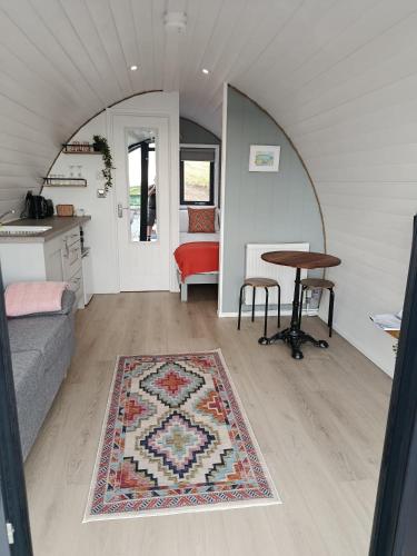a room with a couch and a table and a rug at Hillside Hideaway in Doolin