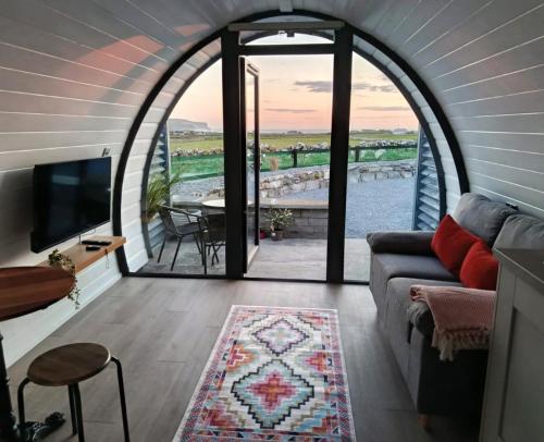 a living room with a couch and a view of the ocean at Hillside Hideaway in Doolin