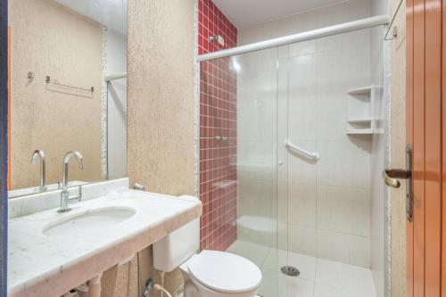 a bathroom with a toilet and a sink and a shower at Kaliman Pousada in Ubatuba