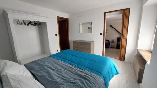 a bedroom with a bed with a blue blanket at La Casa Di Memole in Giaveno