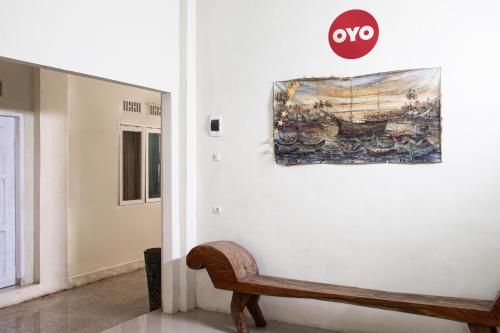 a painting hanging on a wall next to a bench at Hotel O Onong's Homestay Near Dodikjur Rindam XIII/Merdeka in Tomohon